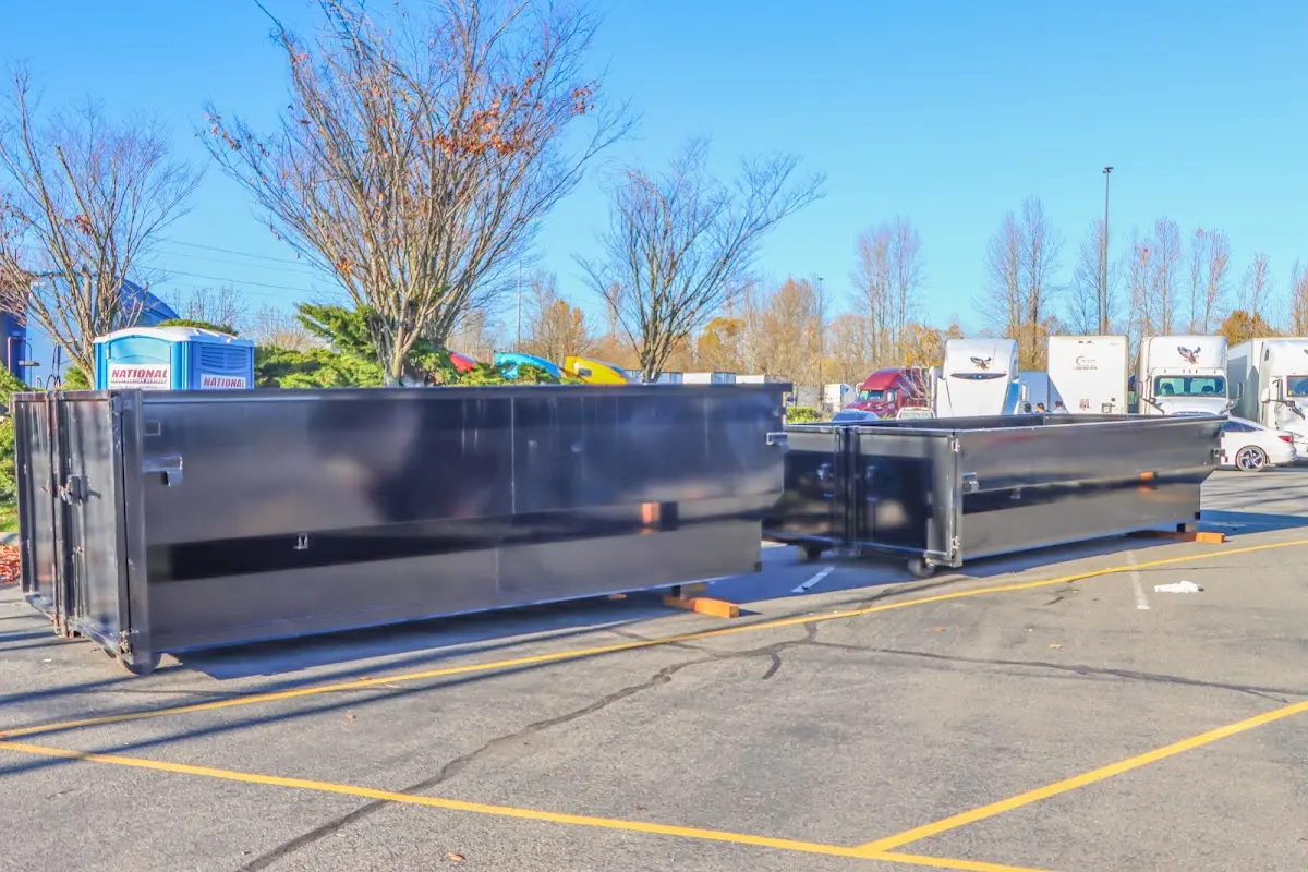 Professional dumpster rental service with roll-off container on residential driveway in Maynard